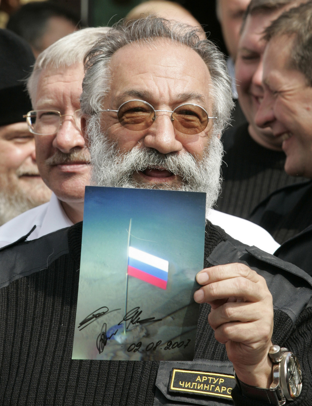 Russian Arctic explorer Artur Chilingarov holds a photograph showing the Russian flag planted on the North Pole seabed, when he returned to Moscow, Russia